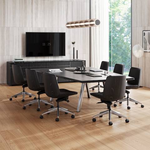 Ascent Conference Table and Credenza by EOOS for DatesWeiser, paired with Clamshell Chairs, shown with a dark grey etched back-painted glass top and chrome base on the table, viewed at an angle in a conference room setting.